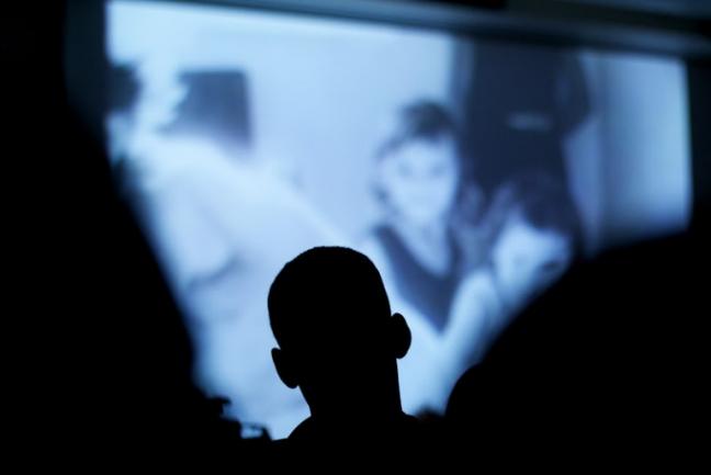 Silhouette of a student in front of a movie screen/